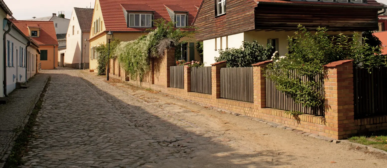 Häuser an einer gepflasterten Straße bei Sonnenschein