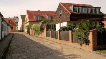 Häuser an einer gepflasterten Straße bei Sonnenschein