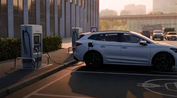 Ein helles E-Auto lädt an einer Ladesäule