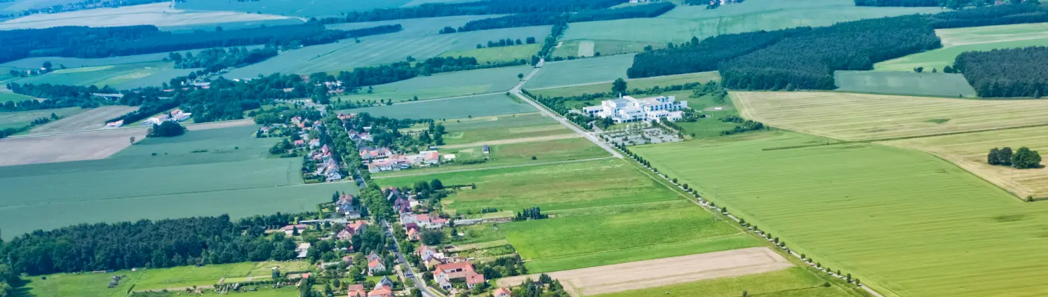 Ein Brandenburger Dorf von Felden umgeben aus der Vogelperspektive.