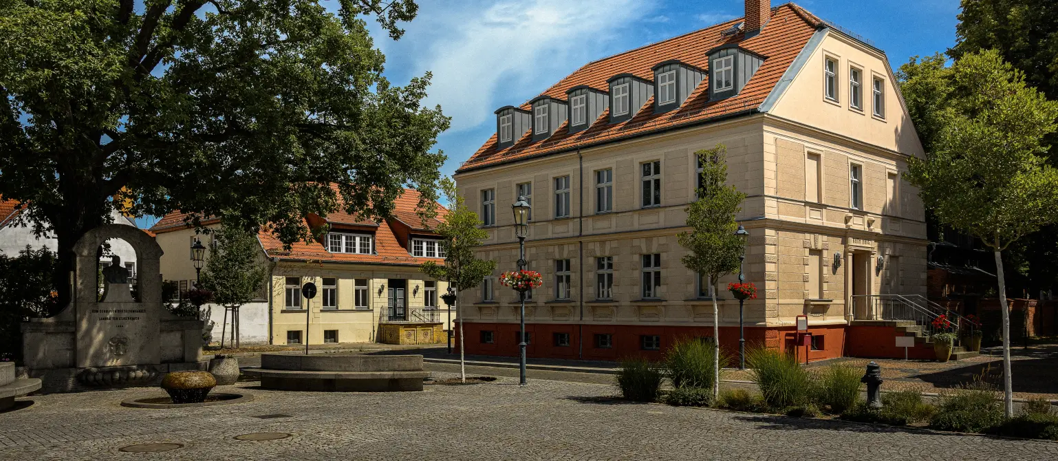 Marktplatz der brandenburgischen Stadt Teltow mit dem alten Rathaus. Auf dem Platz davor ein Brunnen.