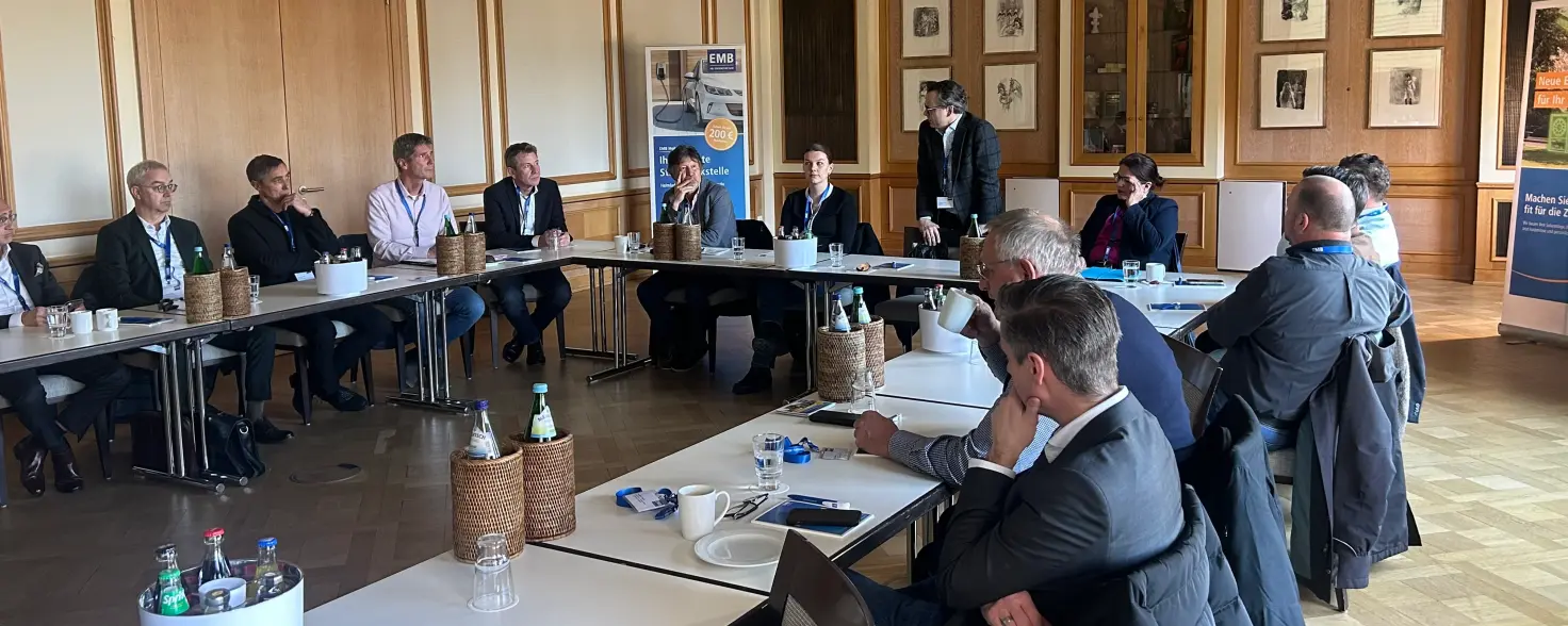 Bürgermeisterinnen und Bürgermeister sitzen beim Stammtisch der Energie Brandenburg um einen Konferenztisch und hören den Vorträgen zu.