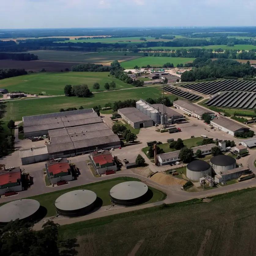 Gebäude der Biogasanlage im brandenburgischen Putlitz aus der Luft. Umgeben von Feldern, Wäldern und Ortschaften.