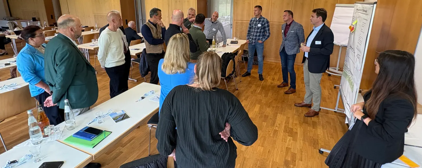 Konferenzraum: Teilnehmende stehen beim Energiedialog von Energie Brandenburg in Burg diskutierend im Kreis.