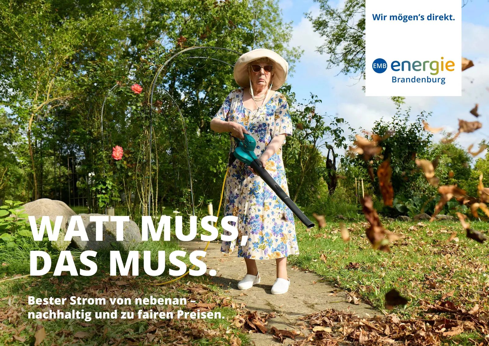 Watt muss, das muss: Eine ältere Frau im geblümten Kleid und mit Sonnenhut fegt das Laub im Garten mit dem Laubbläser zusammen.