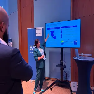Energie Brandenburg Geschäftsführerin Kathrin Jung hält bei Gallery Walk einen Vortrag zum Thema Biomethan vor einem großen Bildschirm.