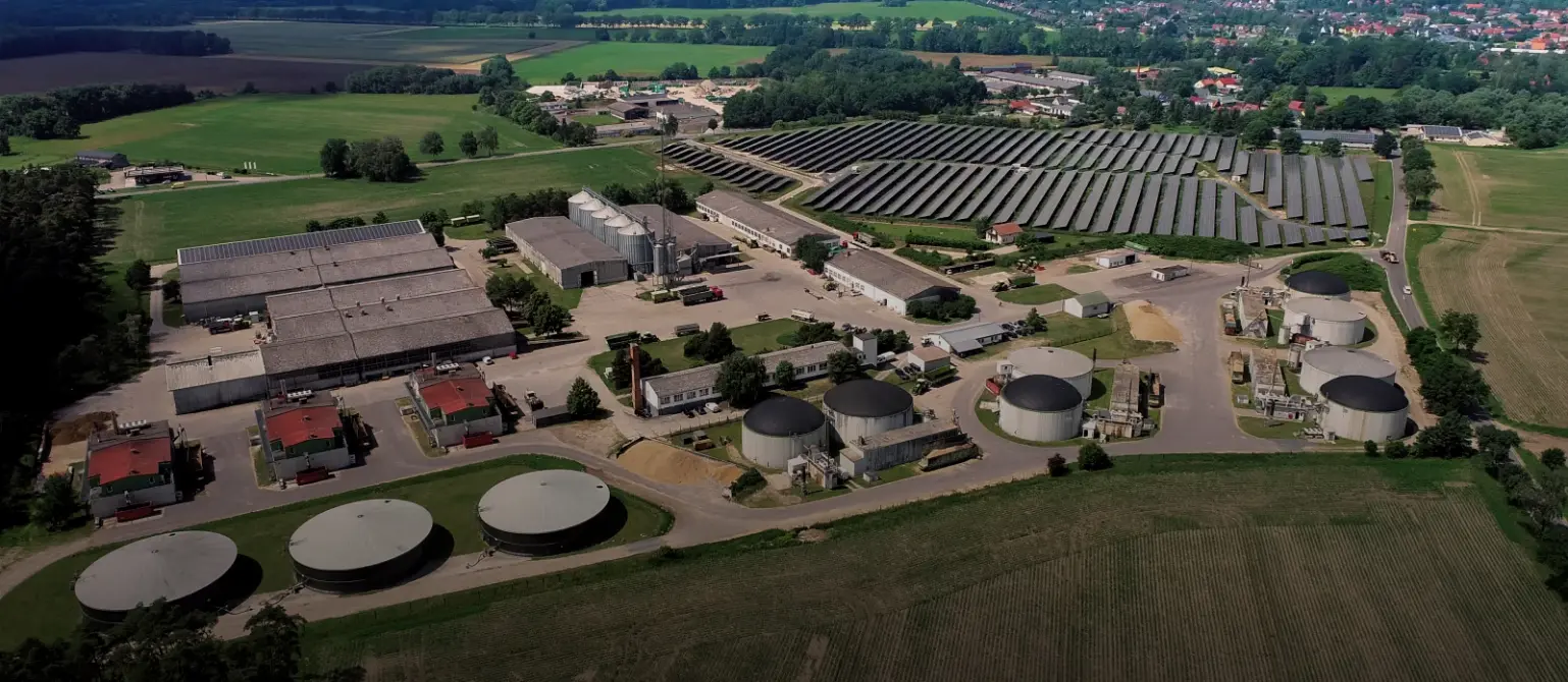 Gebäude der Biogasanlage im brandenburgischen Putlitz aus der Luft. Umgeben von Feldern, Wäldern und Ortschaften.
