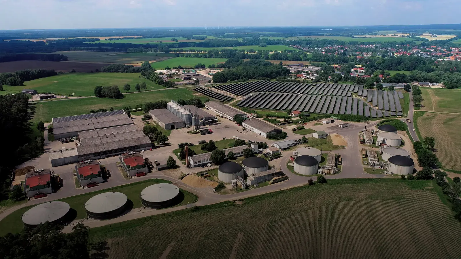 Gebäude der Biogasanlage im brandenburgischen Putlitz aus der Luft. Umgeben von Feldern, Wäldern und Ortschaften.