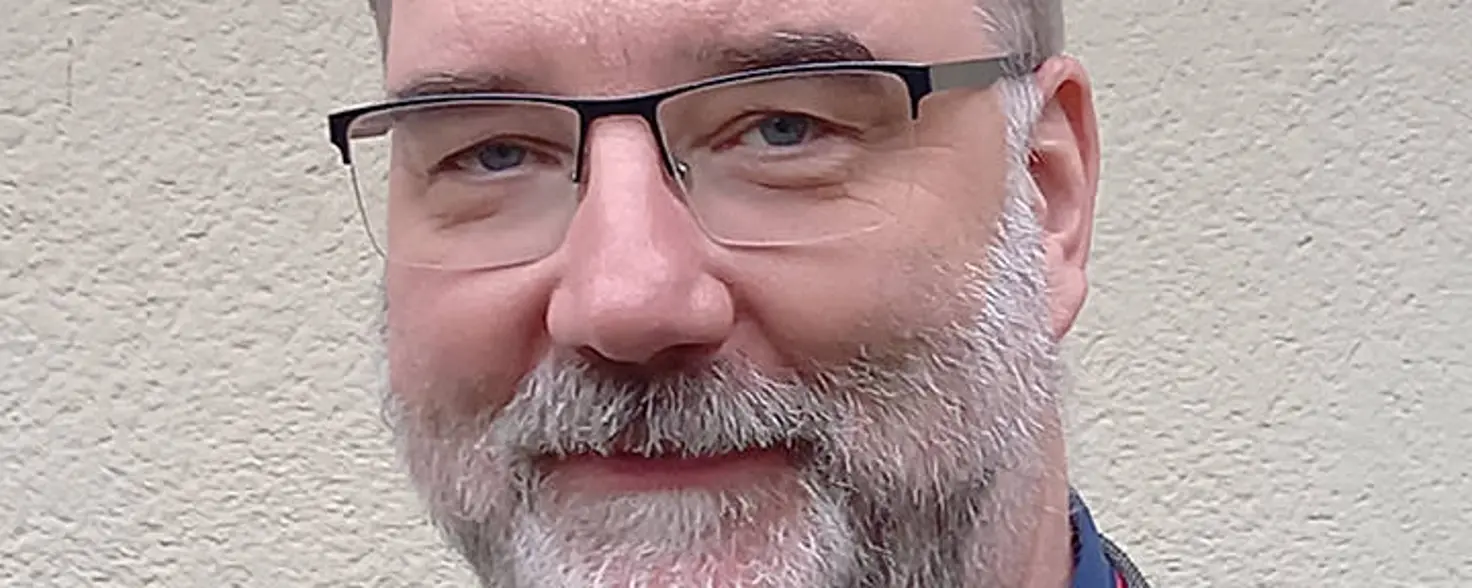 Porträtfoto: Jens Aasmann, Porträtfoto: Jens Aasmann, Amtsdirektor von Rhinow, trägt einen grauen Blazer und lächelt in die Kamera.