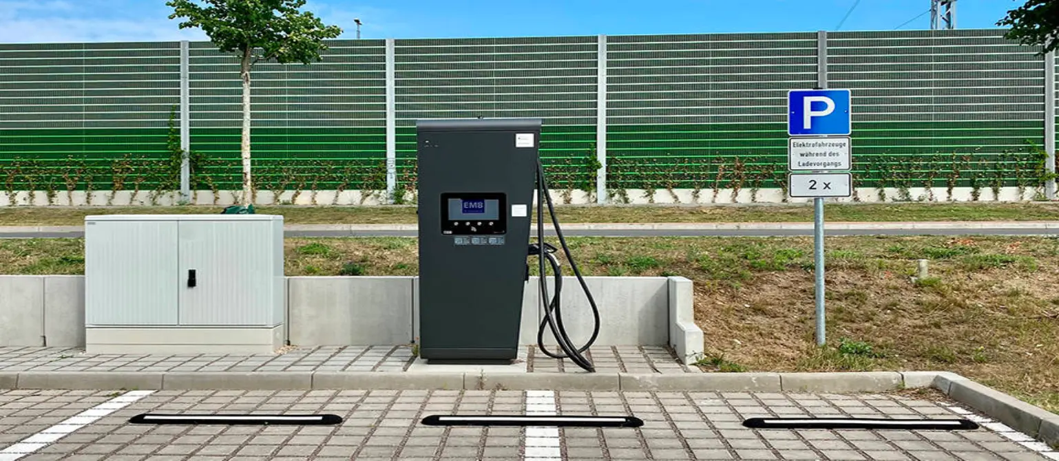 Eine schwarze Schnelladesäule für Elektrofahrzeuge steht an einem Parkplatz in Michendorf.