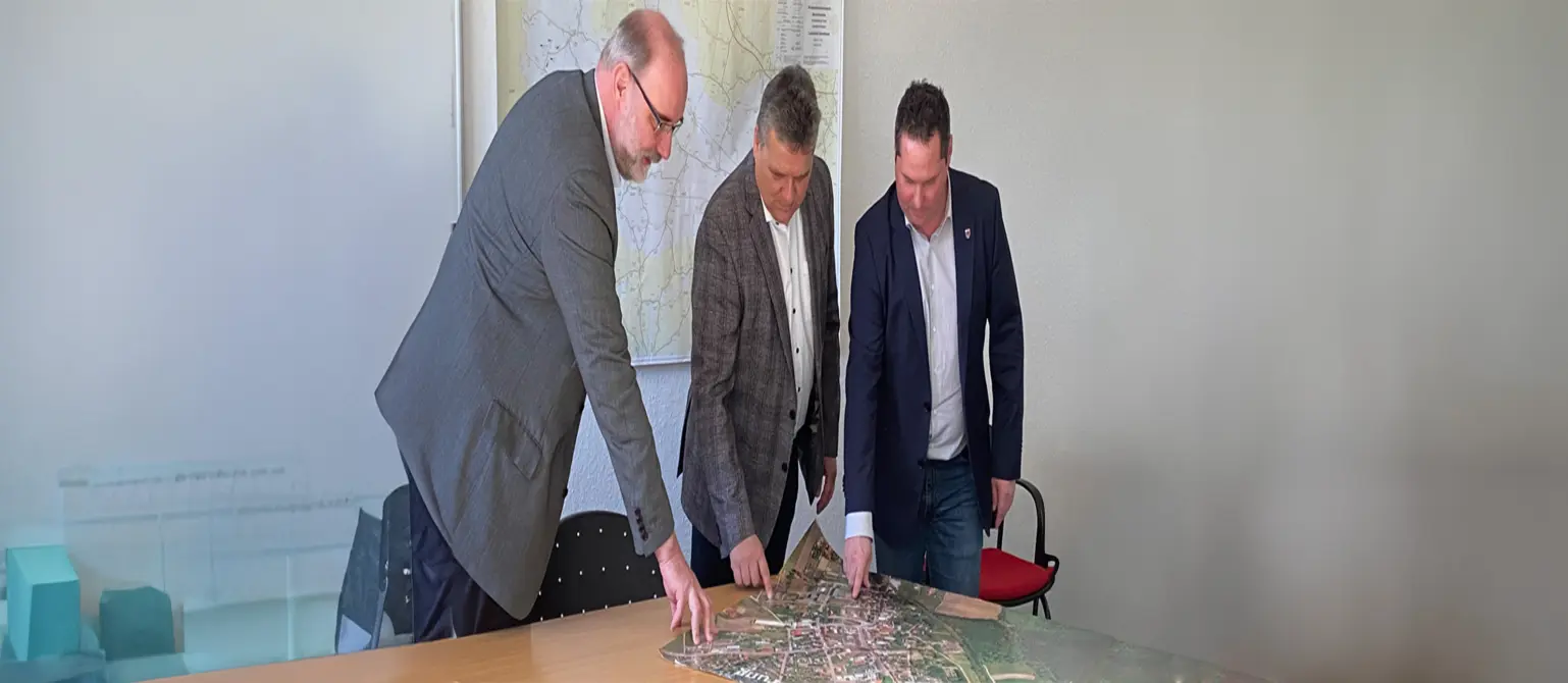 Amtsdirektor Jens Aasmann, EMB-Geschäftsführer Dr. Jens Horn, Bürgermeister Stefan Schneider studieren die Erweiterungspläne für das Wärmenetz Rhinow.