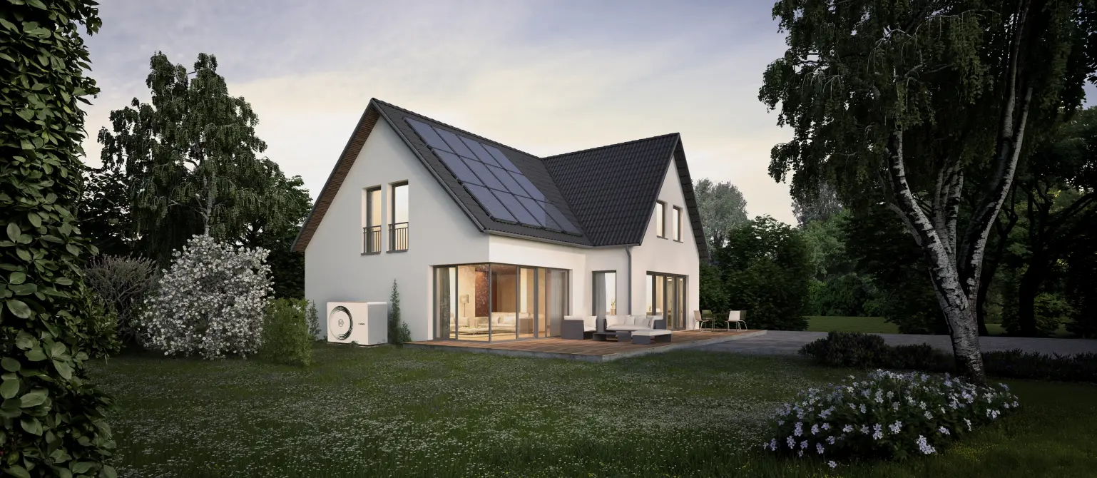 Ein Einfamilienhaus mit PV-Anlage auf dem Dach und Wärmepumpe vor dem Haus