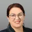 Porträtfoto Kathrin Jung von Energie Brandenburg mit Brille und dunklem Blazer.