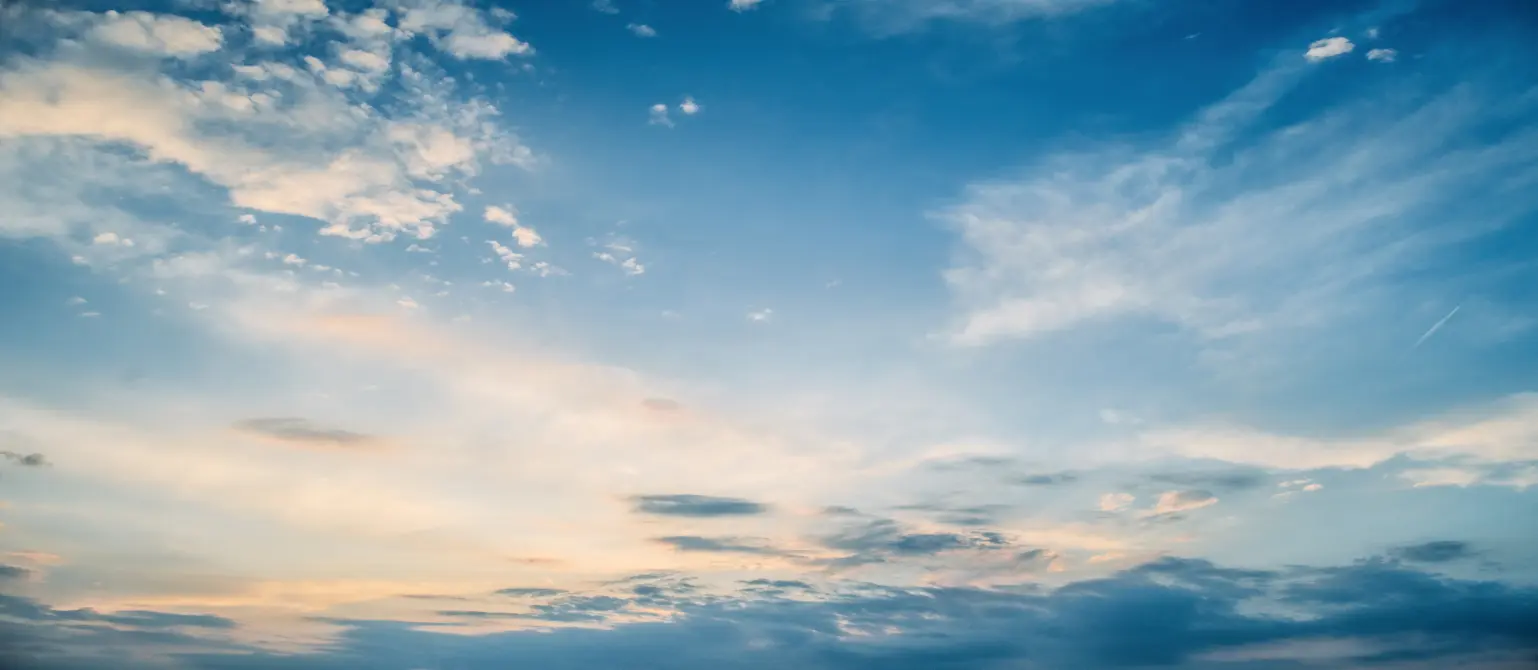 Blauer Himmel mit kleinen Wolken und leichtem Sonnenschein