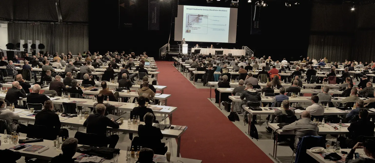 Vortrag bei der Gasfachtagung von Energie Brandenburg 2025: Blick über die Sitzreihen und Köpfe der Teilnehmenden zur Bühne.