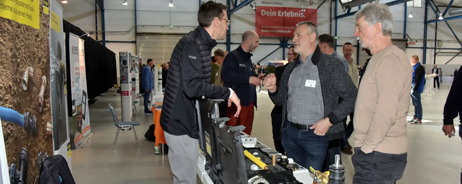 Drei Fachleute im Gespräch an einem Infostand bei der Gasfachtagung 2025 der Energie Brandenburg.
