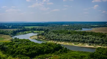 Eine Brandenburger Flusslandschaft mit grünen Wäldern aus der Vogelperspektive.
