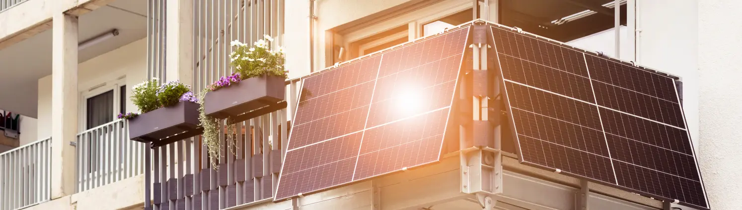 Balkonkraftwerk: Ein moderner Balkon aus Stahl mit Solarpaneelen, die in der Sonne gleißen.