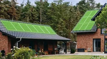 Grüne Simulation einer Solaranlage auf dem Dach von zwei ländlichen Backsteinbauten. Im Hintergrund Wald.