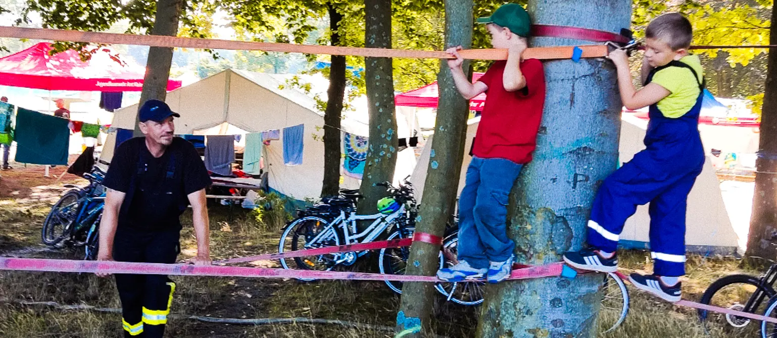 Zwei junge Mitglieder der Jugendfeuerwehr Crinitz balancieren auf zwei straff gespannten Slacklines.