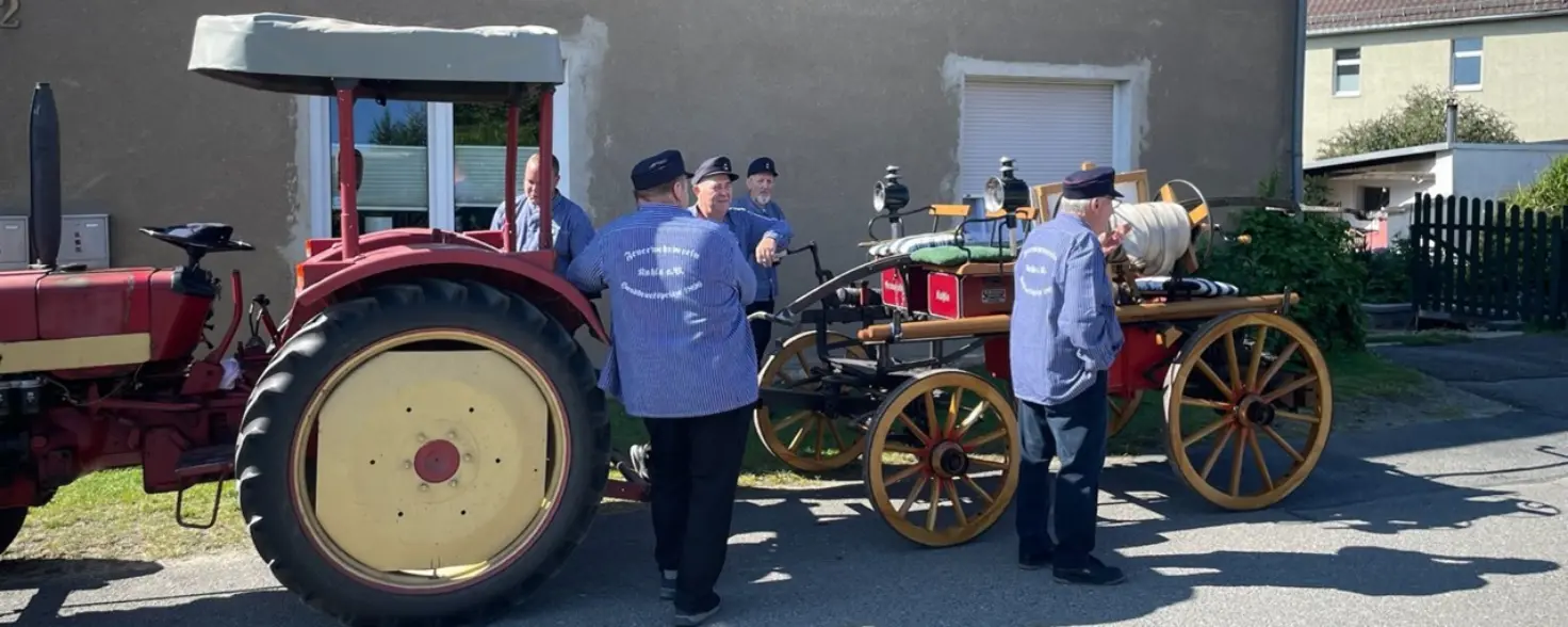Historisches Fahrzeug umgeben von Menschen in Uniform