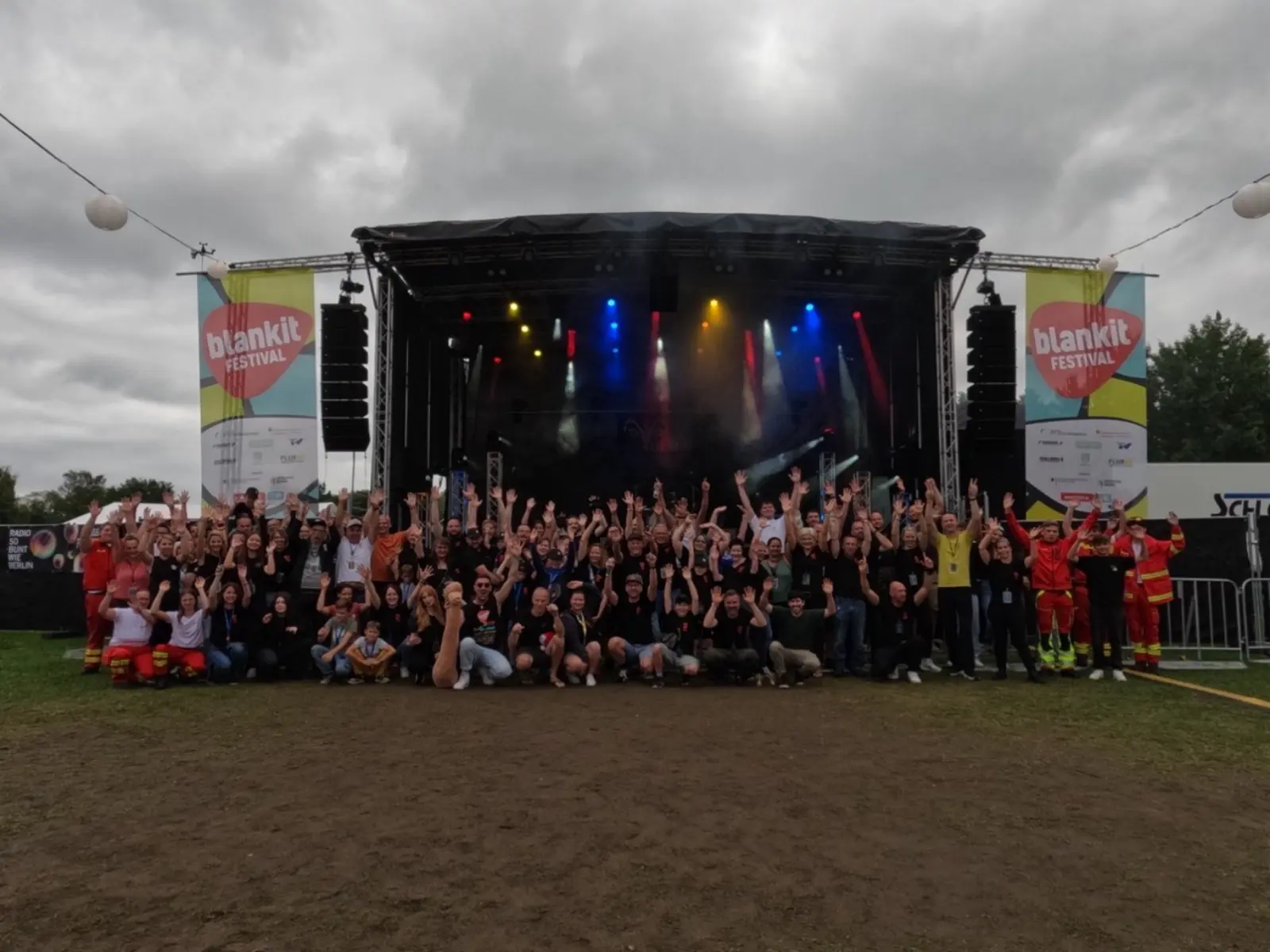 Gruppenfoto: Jubelnde Beteiligte vor der Bühne des 13. Blankit-Festivals im Juli 2025 in Blankenfelde.