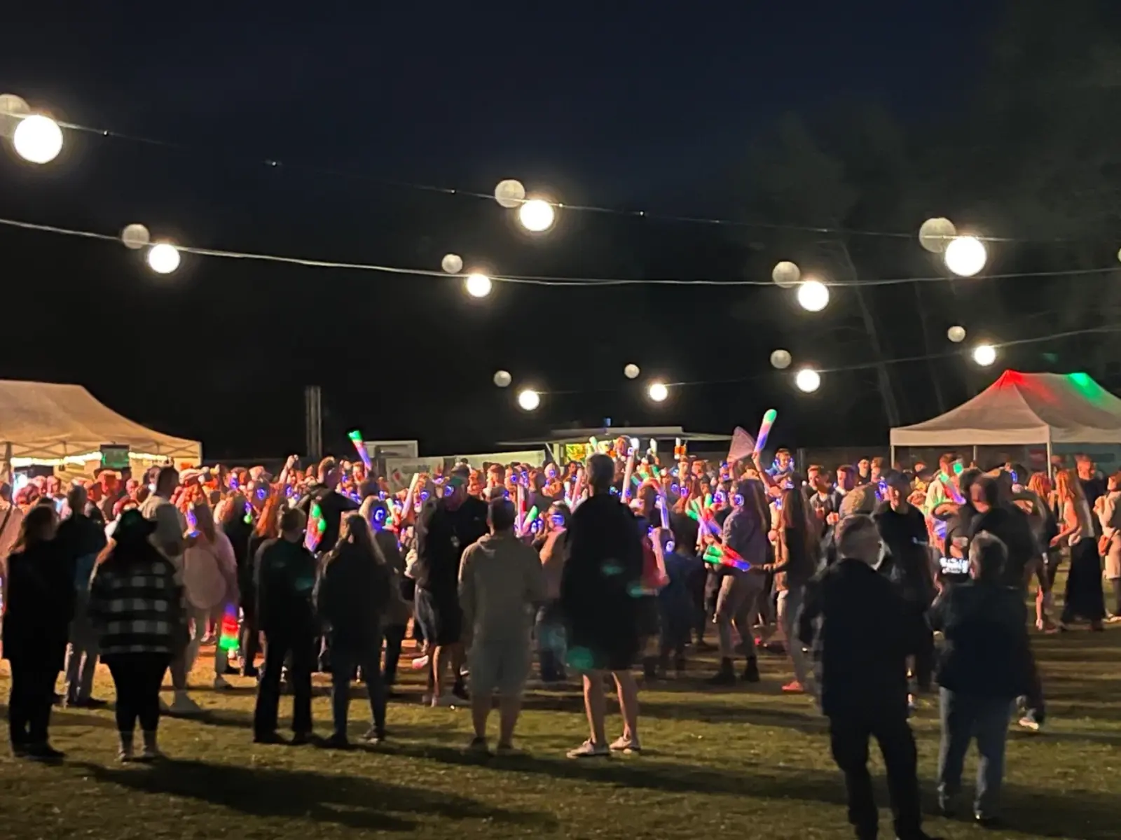 Abendliche Szene: Publikum zwischen bunt beleuchteten Ständen beim 13. Blankit-Festival im Juli 2025 in Blankenfelde.