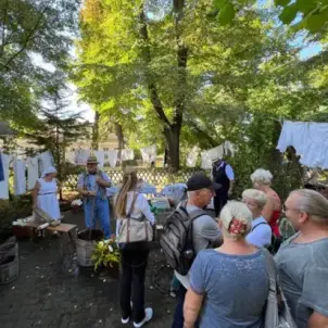 Heimatfest Burg: Menschen in Trachten waschen die Wäsche wie früher in Bottichen.