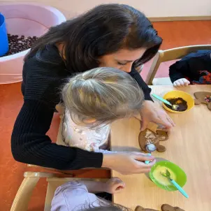 Katharina Kaiser unterstützt ein Kind beim Verzieren des Lebkuchens