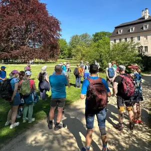 Die Wandergruppe hört den Informationen des Wanderführers zu