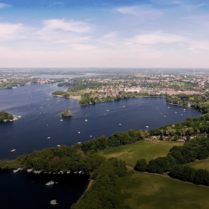 Ein Brandenburger See umgeben von Wald nahe einer Stadt
