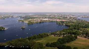 Ein Brandenburger See umgeben von Wald nahe einer Stadt