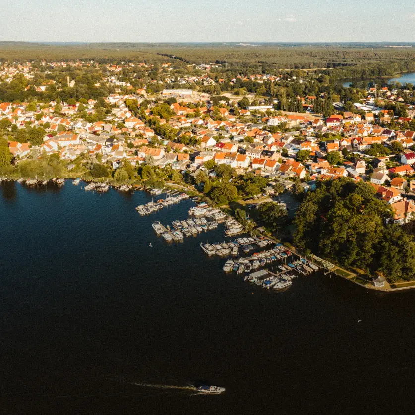 Luftaufnahme: Stadt Brandenburg an der Havel mit Hafen. Im Hintergrund Wälder.