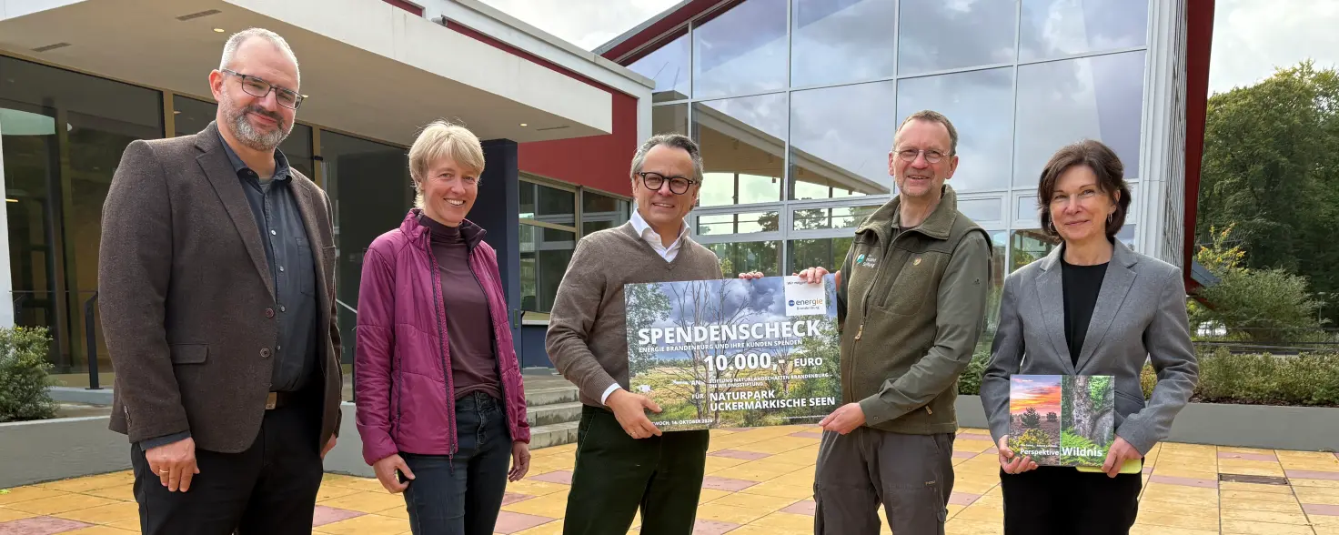 Energie Brandenburg übergibt Naturpark Uckermärkische Seenplatte einen Scheck.