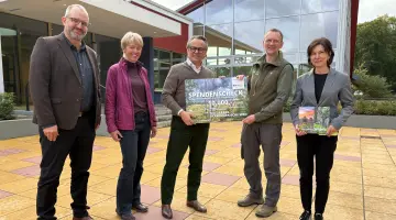 Energie Brandenburg übergibt Naturpark Uckermärkische Seenplatte einen Scheck.
